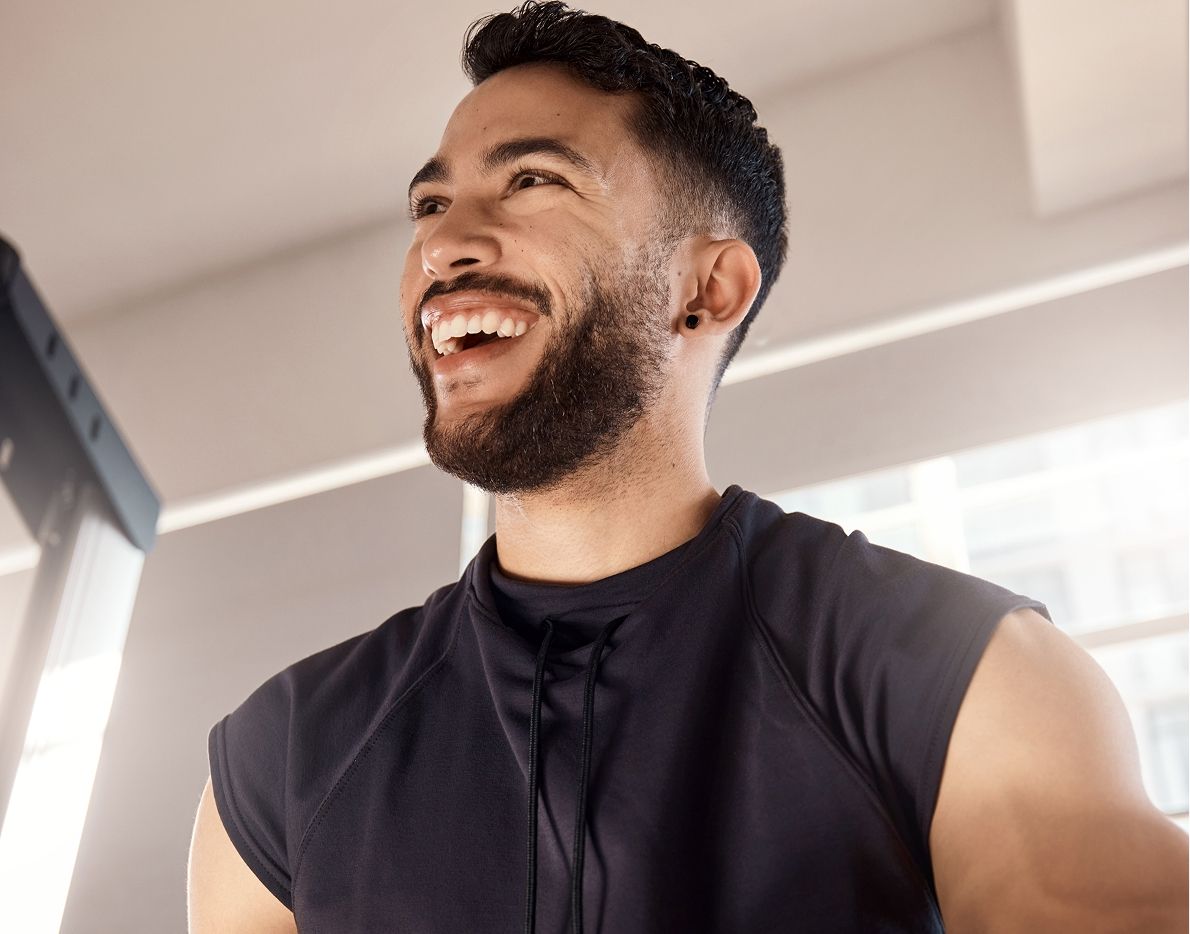 Smiling Dallas HBOT model in sports attire at gym.
