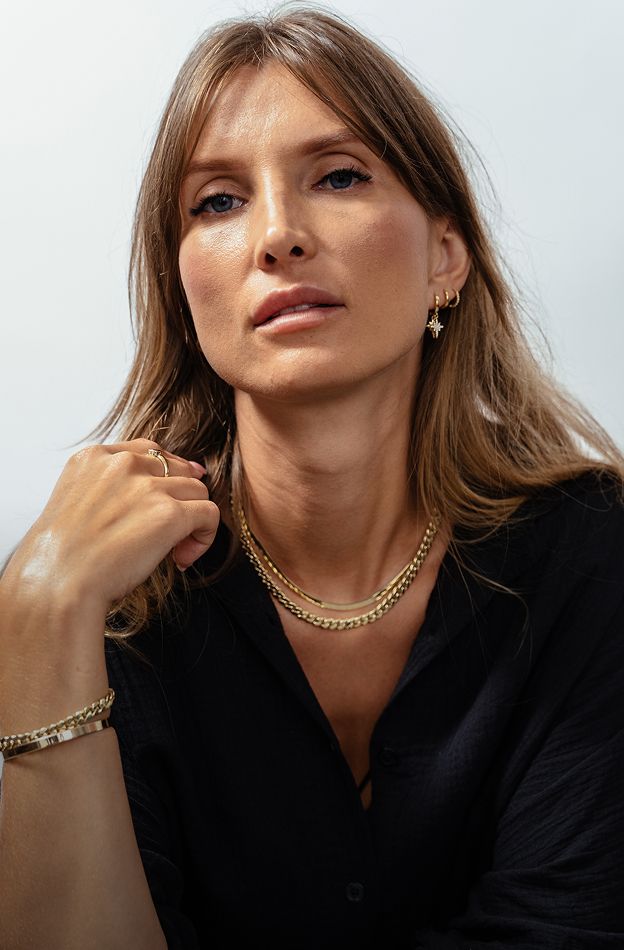 Hyperbaric Oxygen Therapy model wearing elegant gold jewelry and black shirt.